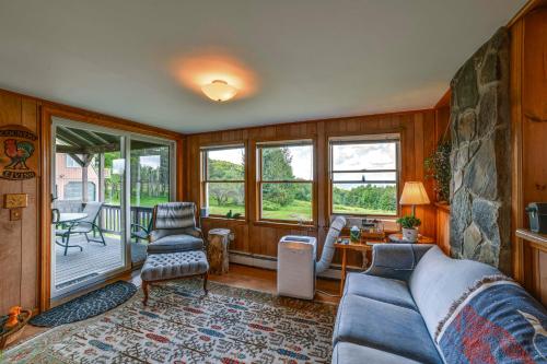 a living room with a couch and a stone wall at Pet-Friendly Catskills Home with Serene Pond! in Jefferson