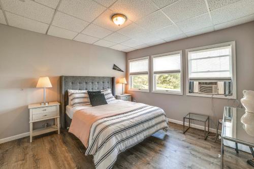 a bedroom with a bed and two windows at Pet-Friendly Catskills Home with Serene Pond! in Jefferson