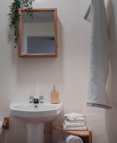 a bathroom with a sink and a mirror and towels at Auberge & Campagne in Saint-Férréol-les-Neiges