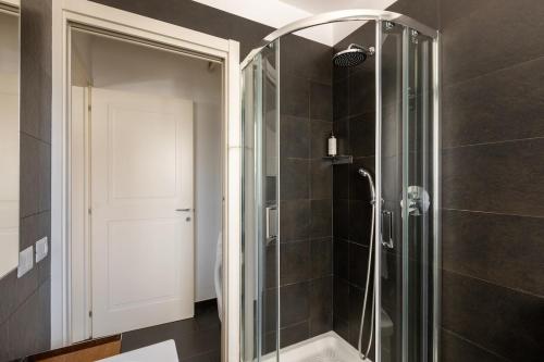un bagno con doccia con porta in vetro di Casa Sacchi by Hili a Roma