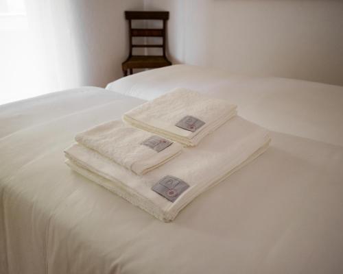 two towels sitting on top of a white bed at Casa d'Abreu Neto - Siza's First Work in Matosinhos