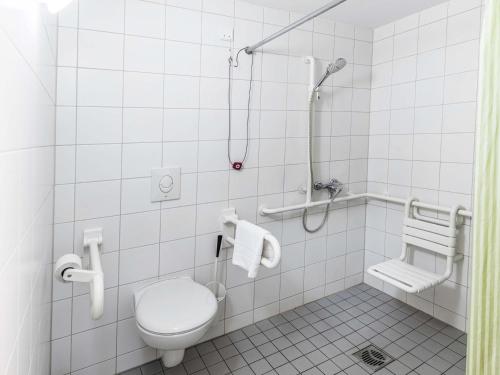 a bathroom with a toilet and a shower at B&B HOTEL Aachen-Nord in Aachen
