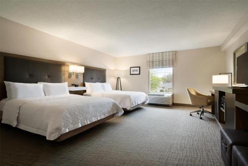 a hotel room with two beds and a window at Hampton Inn & Suites Middletown in Middletown