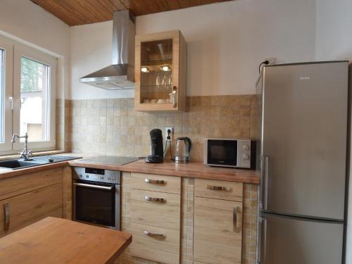 a kitchen with a stainless steel refrigerator and a table at Forest Haven in Filz in Filz