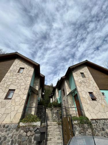 ein paar Gebäude mit wolkigem Himmel im Hintergrund in der Unterkunft Cabaña Amancay, comodidad y tranquilidad a pasos del centro - Ayres del Bosque Alojamientos in San Martín de los Andes