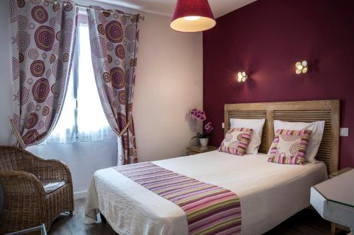 a bedroom with a bed with purple walls and a window at Hotel Toppin in Cavaillon