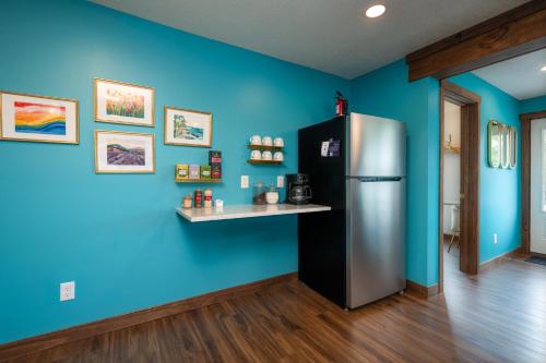 a kitchen with a refrigerator and a blue wall at The Cove Guest House in Prescott