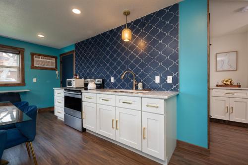 a kitchen with white cabinets and a blue wall at The Cove Guest House in Prescott