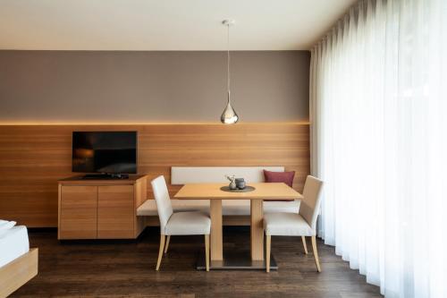 a dining room with a table and chairs at Alagundis Apartment Residence in Lagundo