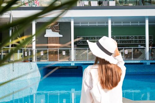 a woman in a hat looking at a building at Hotel Marvel All Inclusive - FULLY RENOVATED FREE Beach Access in Sunny Beach