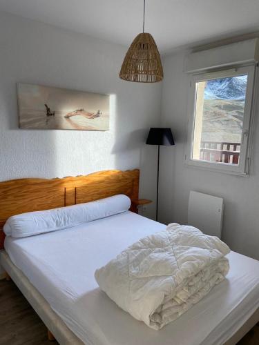 a white bed in a bedroom with a window at Appartement T2 vue sur Pyrénées in Germ