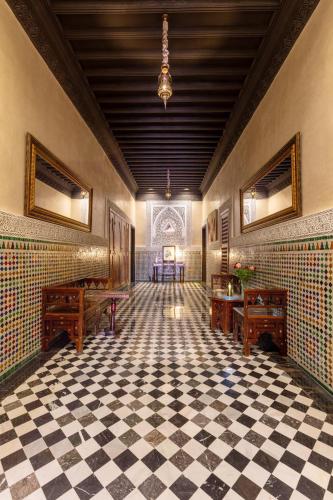 a room with a checkered floor with two desks and tables at L Mansion Villa in Najem