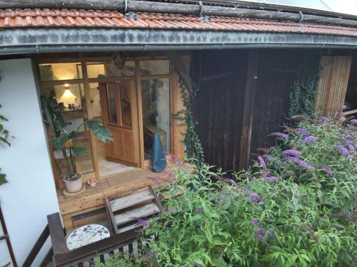 a small house with a window and some plants at Ferienwohnung Rechler in Frasdorf