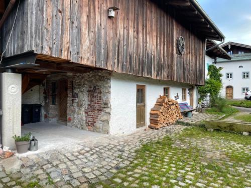 a barn with a pile of wood next to it at Ferienwohnung Rechler in Frasdorf
