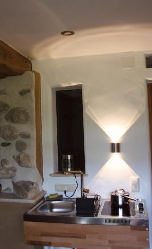 a kitchen with a sink and a stove with a light at Ferienwohnung Rechler in Frasdorf