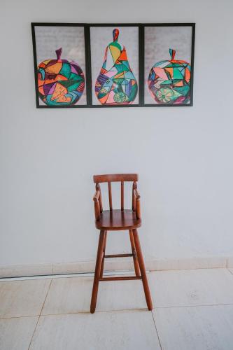 a wooden chair in front of four stained glass windows at Pousada Aconchego Noronha in Fernando de Noronha