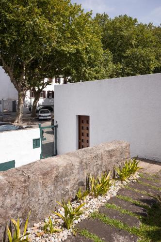 a stone wall with a door in a white building at Casa d'Abreu Neto - Siza's First Work in Matosinhos