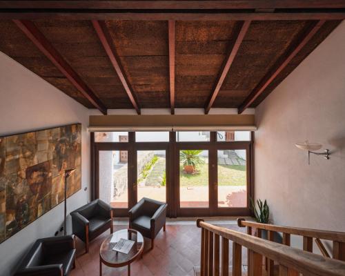 a living room with a table and chairs and a large window at Casa d'Abreu Neto - Siza's First Work in Matosinhos