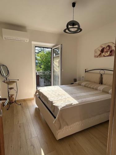 a bedroom with a large bed and a window at Piediluco House - La Casa di Caio in Piediluco