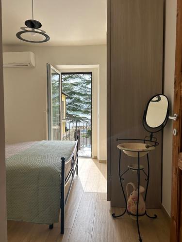 a bedroom with a bed and a mirror and a table at Piediluco House - La Casa di Caio in Piediluco