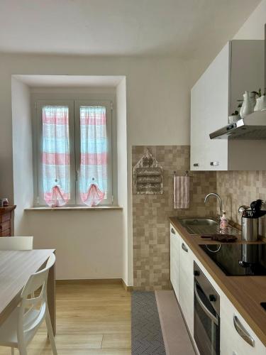 a kitchen with a sink and two windows in it at Piediluco House - La Casa di Caio in Piediluco