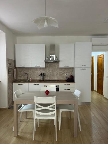 a kitchen with a wooden table and white cabinets at Piediluco House - La Casa di Caio in Piediluco