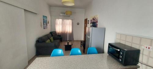 a kitchen with a refrigerator and some blue stools at Magic Sea Apartments in Larnaka
