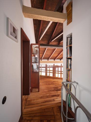 a hallway with a wooden floor and a book shelf at Casa d'Abreu Neto - Siza's First Work in Matosinhos