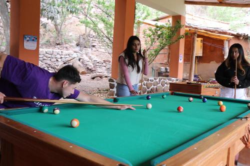a group of people standing around a pool table at EColodge Ccatan in Urubamba