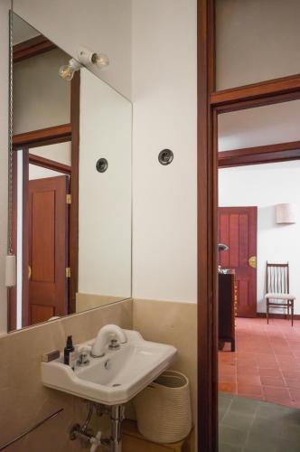 a bathroom with a sink and a mirror at Casa d'Abreu Neto - Siza's First Work in Matosinhos