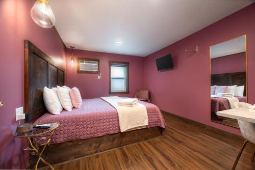 a bedroom with a bed with pink walls at The Cove Guest House in Prescott