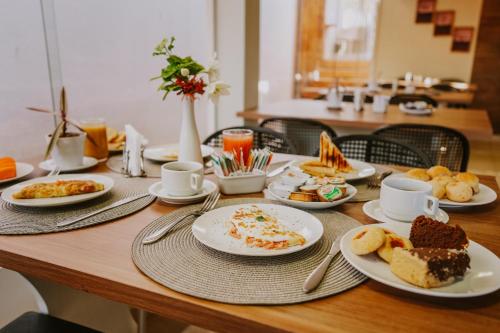 a wooden table with plates of food on it at Pousada Aconchego Noronha in Fernando de Noronha