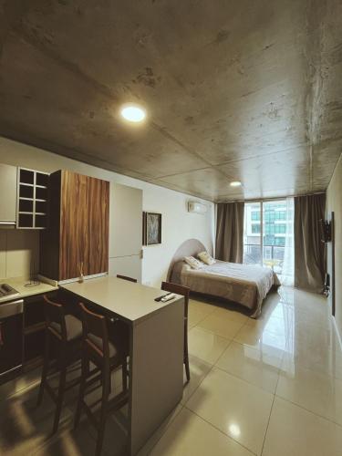 eine Küche und ein Schlafzimmer mit einem Bett und einem Tisch in der Unterkunft Nuevo y moderno departamento a estrenar en el corazón de Fishertoon in Rosario
