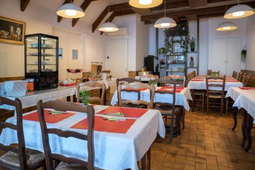 a restaurant with tables and chairs with white tablecloths at Hotel Toppin in Cavaillon