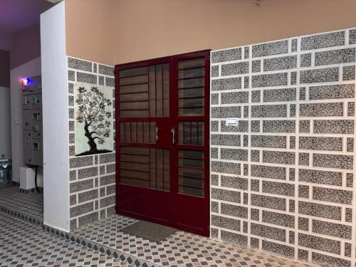 a brick wall with a red door in a room at Samuels Comfort Homes in Bengaluru