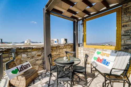 a patio with chairs and a table and two windows at RedBlue Door Two Traditional Listed Houses in Pano Lefkara