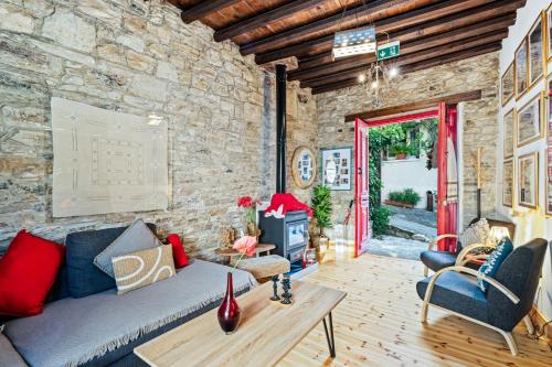 a living room with a couch and a stone wall at RedBlue Door Two Traditional Listed Houses in Pano Lefkara