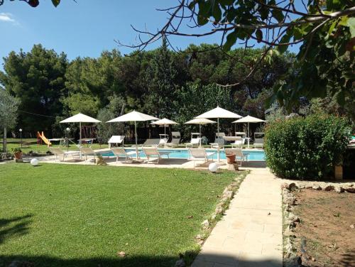 a swimming pool with chairs and umbrellas at Agriturismo Santa Chiara in Alezio