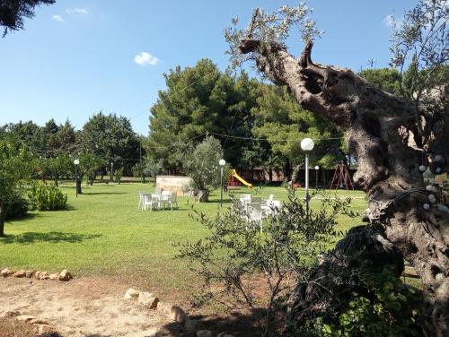 a park with tables and chairs and a playground at Agriturismo Santa Chiara in Alezio