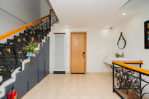 a hallway with a staircase leading to a bathroom with a sink at Aluna Residence Homestay in Da Nang