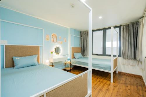 a bedroom with two beds and a mirror at Aluna Residence Homestay in Da Nang