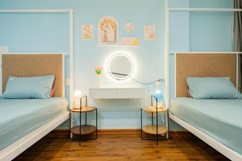 two beds in a room with a mirror and two tables at Aluna Residence Homestay in Da Nang