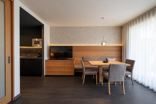 a dining room and kitchen with a table and chairs at Alagundis Apartment Residence in Lagundo