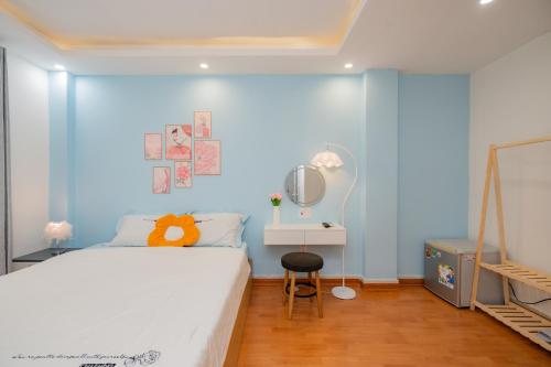 a bedroom with a blue wall with a bed and a mirror at Aluna Residence Homestay in Da Nang
