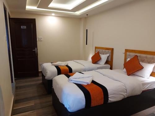 a hotel room with three beds with towels on them at 29 Eleven bed and breakfast in Bungmati
