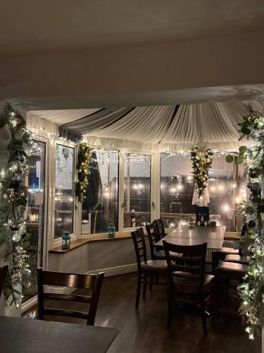 a dining room with a table and chairs and a window at Sids restaurant and bar with rooms in Cardiff