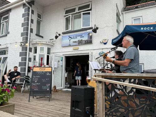 a man playing a guitar in front of a building at Sids restaurant and bar with rooms in Cardiff