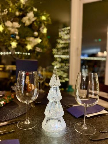 a table with three wine glasses and a christmas tree at Sids restaurant and bar with rooms in Cardiff