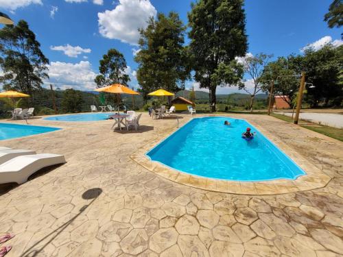 a swimming pool with people in the water at Recanto alto da cachoeira in Mairiporã
