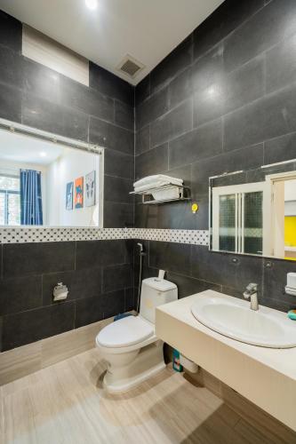 a bathroom with a toilet and a sink and a mirror at Aluna Residence Homestay in Da Nang